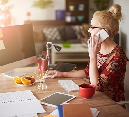 Female business owner on phone with paperwork on desk