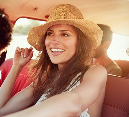 Young woman driving car with friends