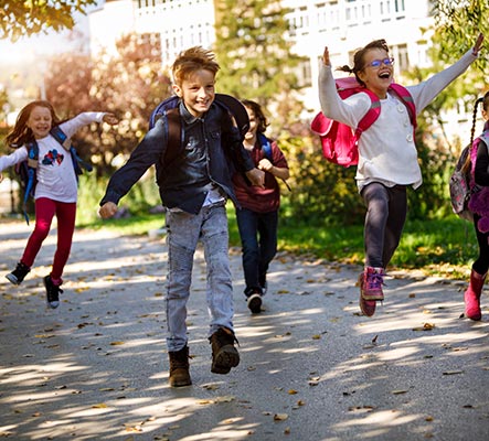 Group of elementary school kids running outside
