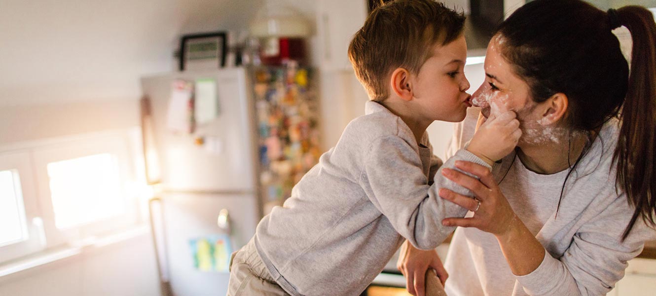 Mother and son baking in kitchen