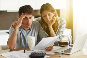 Couple looking at paperwork together looking concerned.