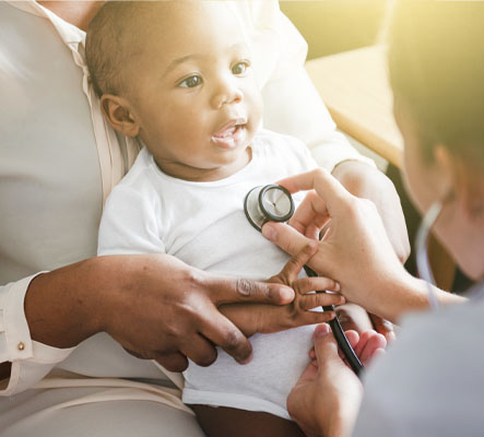 mother holding baby at doctor check up