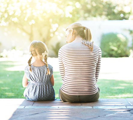 mother and daughter sitting on home steps