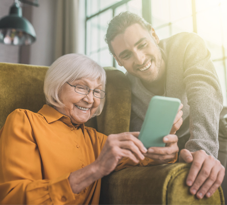 mature woman on mobile phone while young man smiles