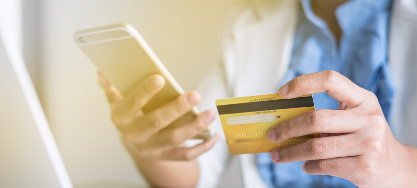 Woman holding her cellphone and credit card.