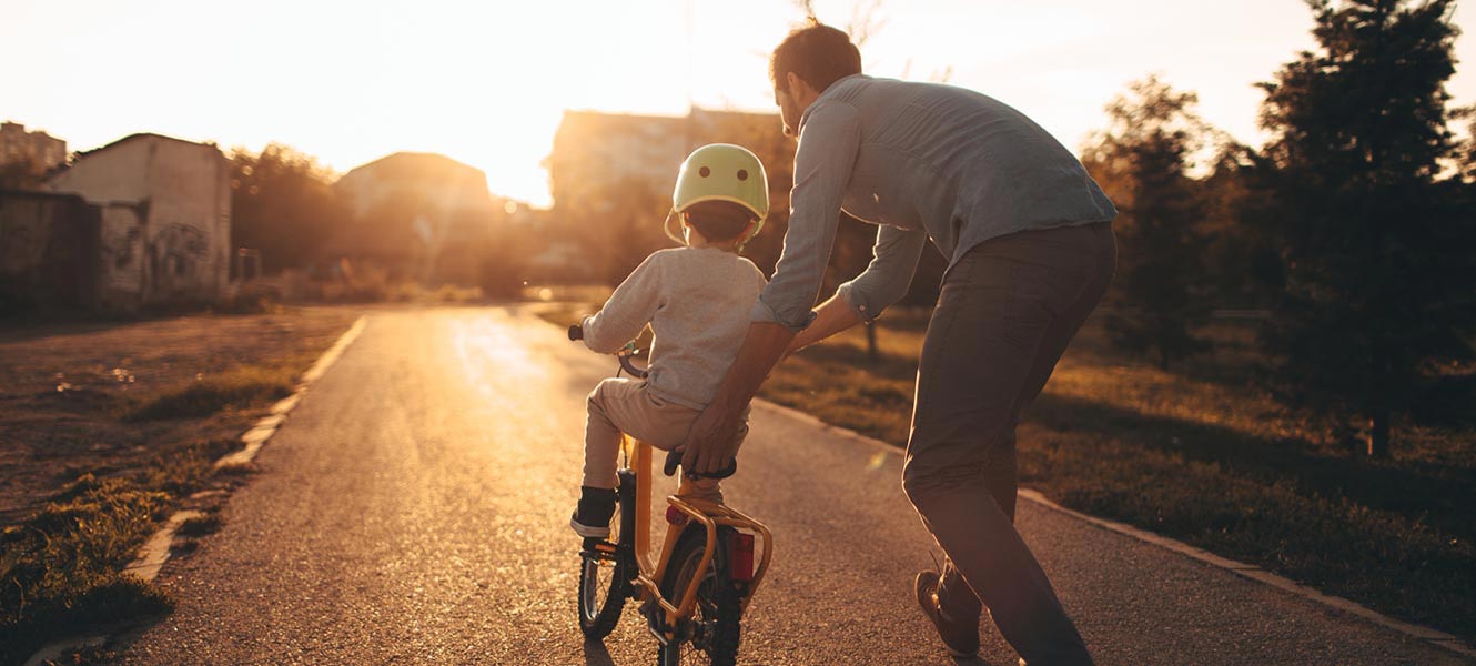 Father teaching son how to ride bike