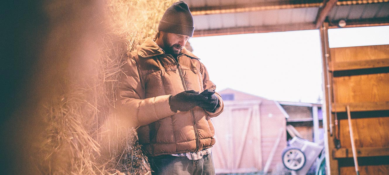 Farmer working on phone in barn