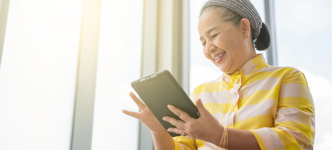A woman looking at her ipad smiling.